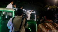 Mereka berdiri di mobil dengan bak terbuka itu. Keduanya juga melambaikan tangan ke para pendukung.