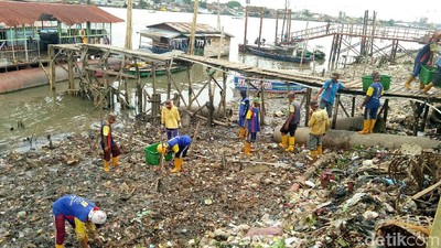 Foto: Petugas Berjibaku Angkut Tumpukan Sampah di Sungai Musi