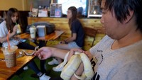 Reptil-reptil tersebut diletakkan dalam tangki kaca yang ditaruh pada dinding kafe. Ada pengunjung yang talut-takut, ada pula yang berani (AFP/GETTY IMAGES) 