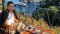 Dengan pemandangan laut lepas yang indah, Ezra tampil keren dengan champagne dan keripik kentang sebagai camilannya. Foto: Instagram @ezrajwilliam