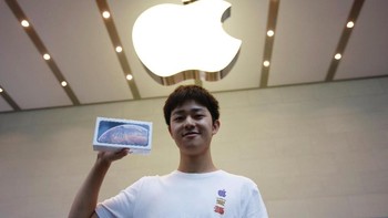 Perjuangannya mengantre tak sia-sia karena berhasil jadi yang pertama membeli iPhone idamannnya. Sungguh fanboy sejati. Foto: Reuters