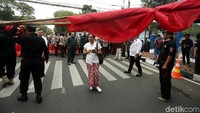 Sementara itu, jalan di depan KPU ditutup dan dijaga ketat oleh polisi. 