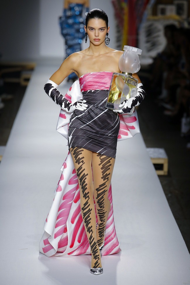 Sosok Kendall muncul di fashion show Spring-Summer 2019 Moschino yang menampilkan deretan gaun unik bermotif coretan spidol. Berbalut mini dress strapless  yang mengekspos bahu dan kaki jenjang, Kendall sukses menebar aura seksinya. Foto: Dok. Getty Images