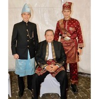 Baju tradisional Banjar khas Kalimantan Selatan menjadi andalan SBY, lengkap dengan topi dan kain adat bernuansa kemerahan.  Adapun kemeja hitam yang dipakai sebagai luaran dihiasi detail payet bernuansa emas pada bagian kerah dan manset. (Foto: Instagram/@aniyudhoyono)