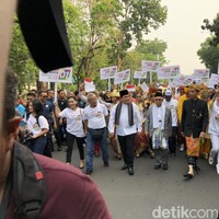 Capres nomor urut 01 yang juga Presiden RI saat ini, Joko Widodo (Jokowi), mengandalkan baju adat khas Bali. Dengan kepala yang dibalut udeng, Jokowi memakai jas tutup hitam yang dipadu dengan tenun endek oranye sebagai sarung. Sementara kakinya beralaskan selop hitam. Penampilan yang sama juga menjadi andalan Jokowi saat menghadiri peresmian Patung Garuda Wisnu Kencana (GWK) di Bali semalam. (Foto: Ray Jordan/detikcom)