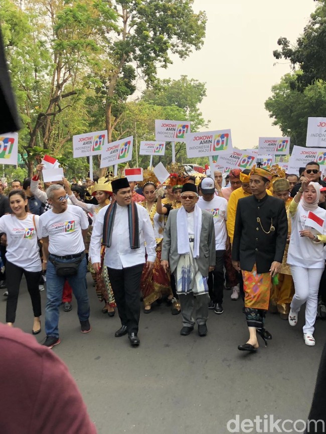 Capres nomor urut 01 yang juga Presiden RI saat ini, Joko Widodo (Jokowi), mengandalkan baju adat khas Bali. Dengan kepala yang dibalut udeng, Jokowi memakai jas tutup hitam yang dipadu dengan tenun endek oranye sebagai sarung. Sementara kakinya beralaskan selop hitam. Penampilan yang sama juga menjadi andalan Jokowi saat menghadiri peresmian Patung Garuda Wisnu Kencana (GWK) di Bali semalam. (Foto: Ray Jordan/detikcom)