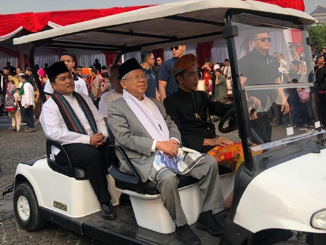 Setelan berjas dan celana abu-abu menjadi pilihan Ma’ruf Amin, cawapres yang mendampingi Jokowi. Ketua Umum Majelis Ulama Indonesia (MUI) itu lalu memadukannya dengan peci hitam, berikut syal putih serta sarung bercorak kebiruan yang dililit di luar celana. (Foto: Ray Jordan/detikcom)
