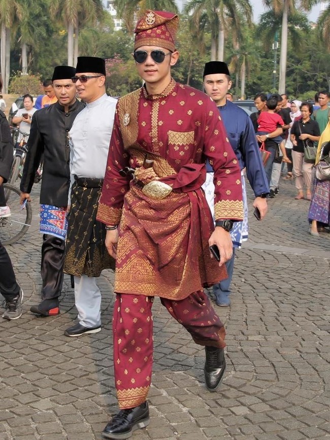 Putra Sulungnya, AHY, juga memilih baju adat bernuansa merah. Tapi kali ini pilihannya jatuh pada busana khas Melayu dari Riau yang dilengkapi sabuk emas beserta senjata tradisional. Seperti ayahnya, ia juga memakai kacamata hitam aviator. (Foto: Instagram/@agusyudhoyono)