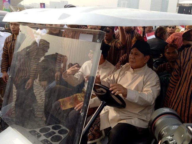 Sementara itu, Prabowo Subianto, capres nomor urut 02, berbalut baju beskap krem, kain jarik coklat tua yang dililit di bagian pinggang, serta celana panjang hitam. Tidak ketinggalan, belangkon hitam yang semakin menyempurnakan gaya kejawaan Ketua umum Partai Gerindra itu. Tak cuma Prabowo, pengawalnya pun ikut berbelangkon. (Foto: Gibran/detikcom)