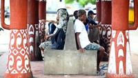 Beberapa warga tengah menunggu angkutan umum di terminal.