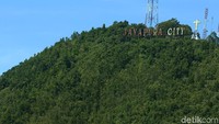 Di puncaknya terdapat plang Kota Jayapura yang ikonik.