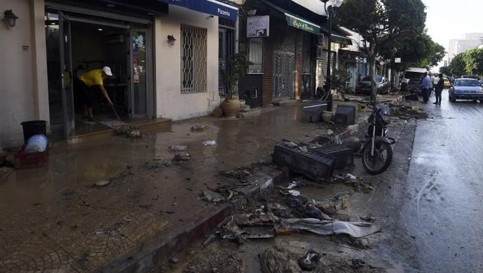 A picture taken on September 23, 2018, in the Tunisian coastal governante of Nabeul shows  people standing in a muddy street following deadly flash flooding in the town of Bir Challouf.
Torrential rains and flooding in northeastern Tunisia have left at least four dead, including two sisters, the interior ministry said. / AFP PHOTO / FETHI BELAID