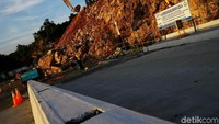 Di wilayah itu, alat-alat berat masih cukup menumpuk untuk merapikan jalan. Truk-truk juga masih banyak hilir-mudik di sana. Jalan akses itu masih dipenuhi batuan kerikil.