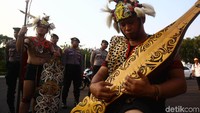 Seorang pendemo memainkan alat musik.