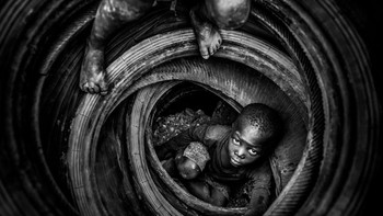 Boulmigou: The Paradise of Forgotten Hearts oleh fotografer Antonio Aragón Renuncio. Bisa disaksikan anak-anak sedang bermain dengan ban bekas yang kemudian akan dibakar di Burkina Faso. Mereka rentan terpapar polusi dan penyakit pernapasan, bahkan kematian. Foto: Environmental Photographer Of The Year