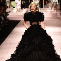 Tampilan Eva Herzigova mewah dan dramatis dalam balutan gaun hitam transparan berdetail ruffle. Foto: Miguel MEDINA / AFP