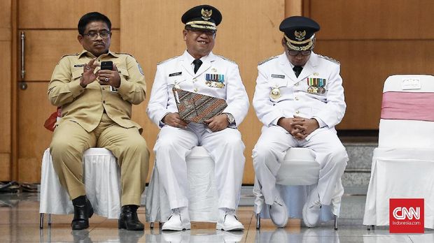 Bupati Tulungagung non-aktif Syahri Mulyo (kanan) tertunduk di kantor Kemendagri, Jakarta, Rabu, 25 September.