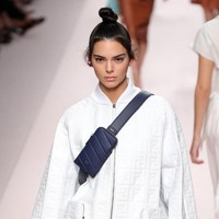Gaya Kendall Jenner pakai baju tanpa celana terlihat kasual namun tetap glamor. Jaket oversized dipadukan dengan tas berwarna senada, sepatu kitten heels dan fanny pack biru navy. Foto: Getty Images