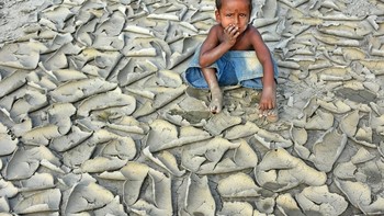 Dryness oleh fotografer India, Chinmon Biswas, jadi yang terbaik kategori perubahan iklim. Memperlihatkan seorang anak termenung di atas hamparan tanah yang begitu kering. Foto: Environmental Photographer Of The Year