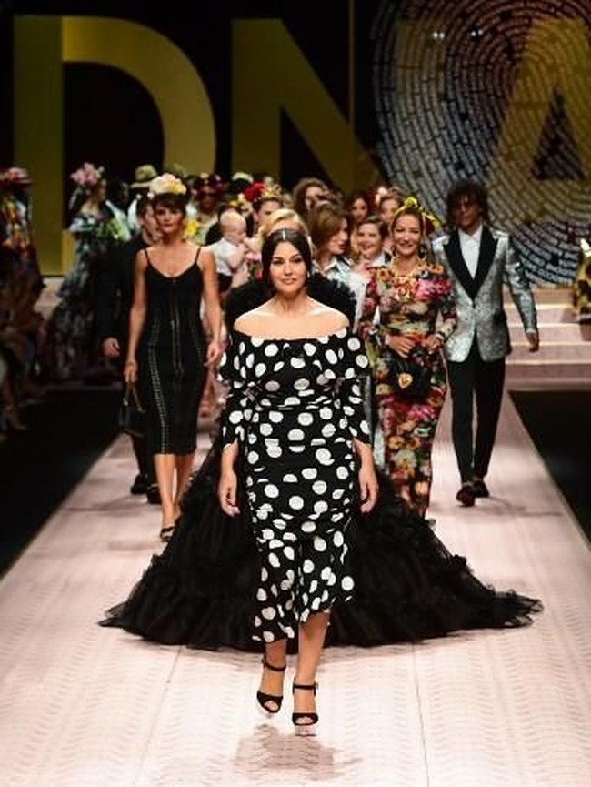 Aktris Monica Bellucci tampil dengan gaun off-shoulder bermotif polka dot yang playful. Wajahnya yang masih cantik di usia 53 tahun dirias dengan makeup nuansa nude dan natural. Foto: Miguel MEDINA / AFP