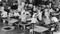 Sejumlah pekerja wanita sedang melakukan penyortiran daun teh di salah satu perkebunan di Jawa. Three Lions/Hulton Archive/Getty Images.