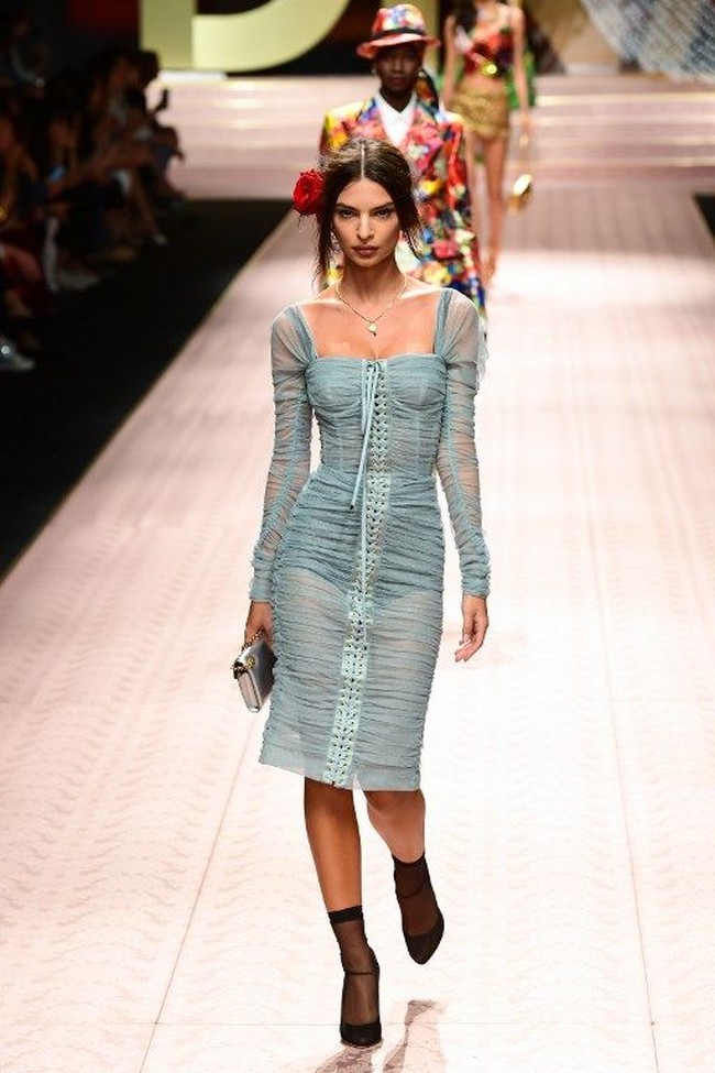 Lama tak eksis di catwalk, Emily Ratajkowski tampil dengan gaun smocked warna dusty blue berdetail tali. Koleksi Dolce & Gabbana kali ini banyak menampilkan detail feminin seperti renda, lace, bordir hingga mawar. Foto: Miguel MEDINA / AFP
