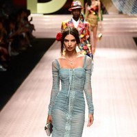 Lama tak eksis di catwalk, Emily Ratajkowski tampil dengan gaun smocked warna dusty blue berdetail tali. Koleksi Dolce & Gabbana kali ini banyak menampilkan detail feminin seperti renda, lace, bordir hingga mawar. Foto: Miguel MEDINA / AFP
