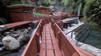 Tak jauh dari jembatan pula ruang ganti dari kayu bercat merah di setiap kolam air panas, dengan rumput hijau yang ditanam di atapnya (Termas Geometricas)