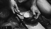 Seorang pekerja di pabrik kelapa sedang mengambil daging kelapa untuk diproduksi dan dijual sebagai kopra. Keystone Features/Getty Images.  