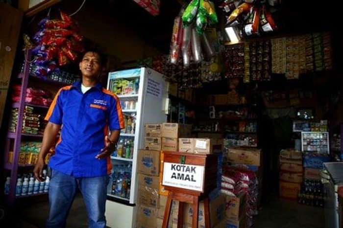 Muhammad Syukur berdiri di depan tokonya yang juga menjadi BRILink di Skouw (Dok. Detikcom) Muhammad Syukur berdiri di depan tokonya yang juga menjadi BRILink di Skouw (Dok. Detikcom)