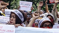 Para pegawai honorer membentangkan poster-poster di depan Balai Kota DKI Jakarta. Salah satu poster bertuliskan Status Honorer K2 Mau Sampai Kapan?.