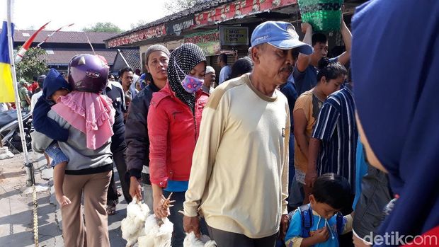 Warga membawa ayam hidup yang dibagikan gratis oleh peternak