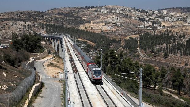 The Palestinian village of Beit Iksa in the occupied West Bank is seen in the background as Israel's new high-speed rail line travels on its tracks in Jerusalem September 25, 2018. REUTERS/Ammar Awad