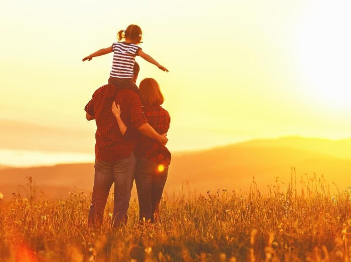 Happy family: mother father and child daughter on nature  on sunset