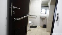 Kondisi toilet di Wisma Atlet Kemayoran. Di setiap pintunya dipasangi besi untuk berpegangan.