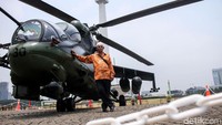 Seorang warga saat berfoto bersama helikopter tempur di pameran alutsista yang digelar TNI di Monas, Jakarta, Kamis (27/9/2018).