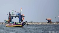 Sebuah perahu nelayan tampak sedang mencari ikan di teluk Jakarta.