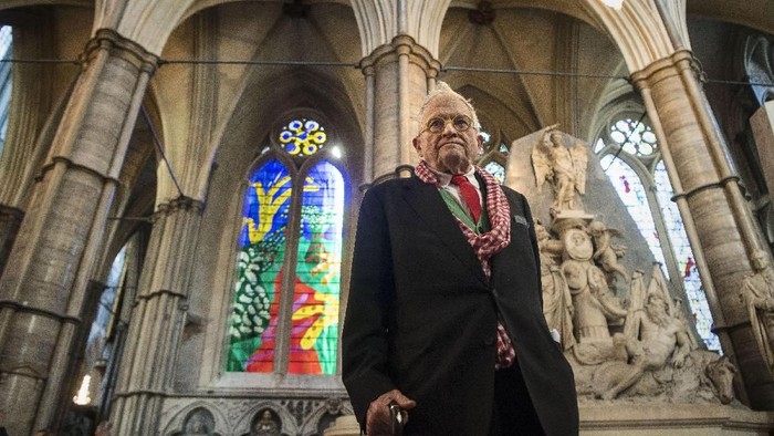 LONDON, ENGLAND - SEPTEMBER 26: Artist David Hockney poses in front of The Queens Window, a new stained glass window at Westminster Abbey he designed and which was created by Barley Studio York, as it is revealed for the first time on September 26, 2018 in London, England. The window - the artists first work in stained glass - reflects the Queens love for and connection with the countryside.  (Photo by Victoria Jones - WPA Pool/Getty Images)