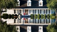 Air yang terus meninggi dan membanjiri pemukiman warga membuat sejumlah orang menggunakan perahu untuk melakukan evakuasi. Sean Rayford/Getty Images.