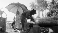 Seorang tukang las sedang memperbaiki pipa sebuah kilang minyak yang berada di Sumatera sekitar tahun 1955.  