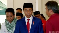 Jokowi hadir dengan menggunakan peci hitam dan jas biru tua dilengkapi dengan dasi berwarna merah. Presiden RI itu datang didampingi Ketum PPP Romahurmuziy (Rommy).