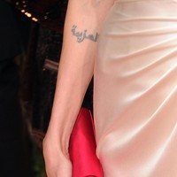 Dekat siku tangan kanan Angelina Jolie, ada tato berbahasa Arab yang bisa diartikan sebagai keteguhan. (Foto: Getty Images)