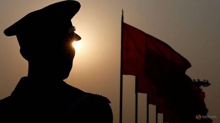 File photo: A paramilitary police officer is seen silhouetted in front of flags. (Photo: REUTERS/Aly Song)
