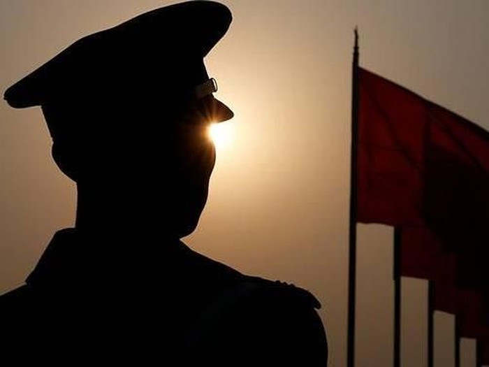 File photo: A paramilitary police officer is seen silhouetted in front of flags. (Photo: REUTERS/Aly Song)