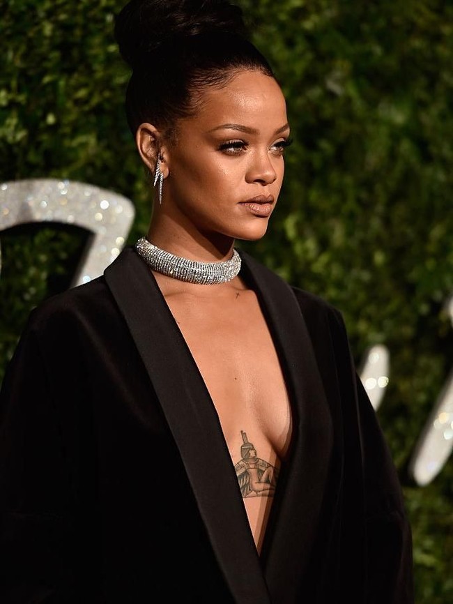 Mentato tubuh menjadi salah satu cara bagi Rihanna untuk mengenang sang nenek. Setelah neneknya meninggal, Rihanna mentato bagian dadanya dengan gambar Dewi Isis dari Mesir Kuno. Goddess Isis - Complete Woman - Model for future generations - #GRANGRANDOLLY - always in and on my heart #1love, tulis Rihanna di Instagram. (Foto: Getty Images)