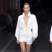 Bella Hadid muncul dengan blus berbelahan dada yang seksi. Kaki jenjangny ditopang dengan heels beraksen temali. (Foto: Dok. Vogue)