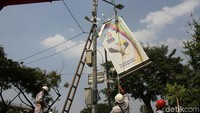 Dengan crane, petugas memasang neon box Asian Para Games 2018.
