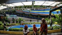 Beberapa pejalan kaki melepas lelah di sekitar taman yang asri.