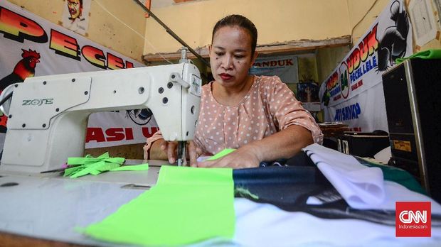 Sriningsih, istri Har, membuat lis [bordir] spanduk pecel lele Lamongan.