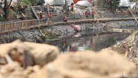 Adanya beton-beton di Kali Grogol membuat sampah menumpuk sehingga petugas PPSU setempat langsung membersihkan sampah itu agar tak mengganggu dan menumpuk di Kali Grogol selama proses pemasangan tura berlangsung.